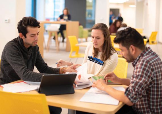 Three students sitting around a table studying