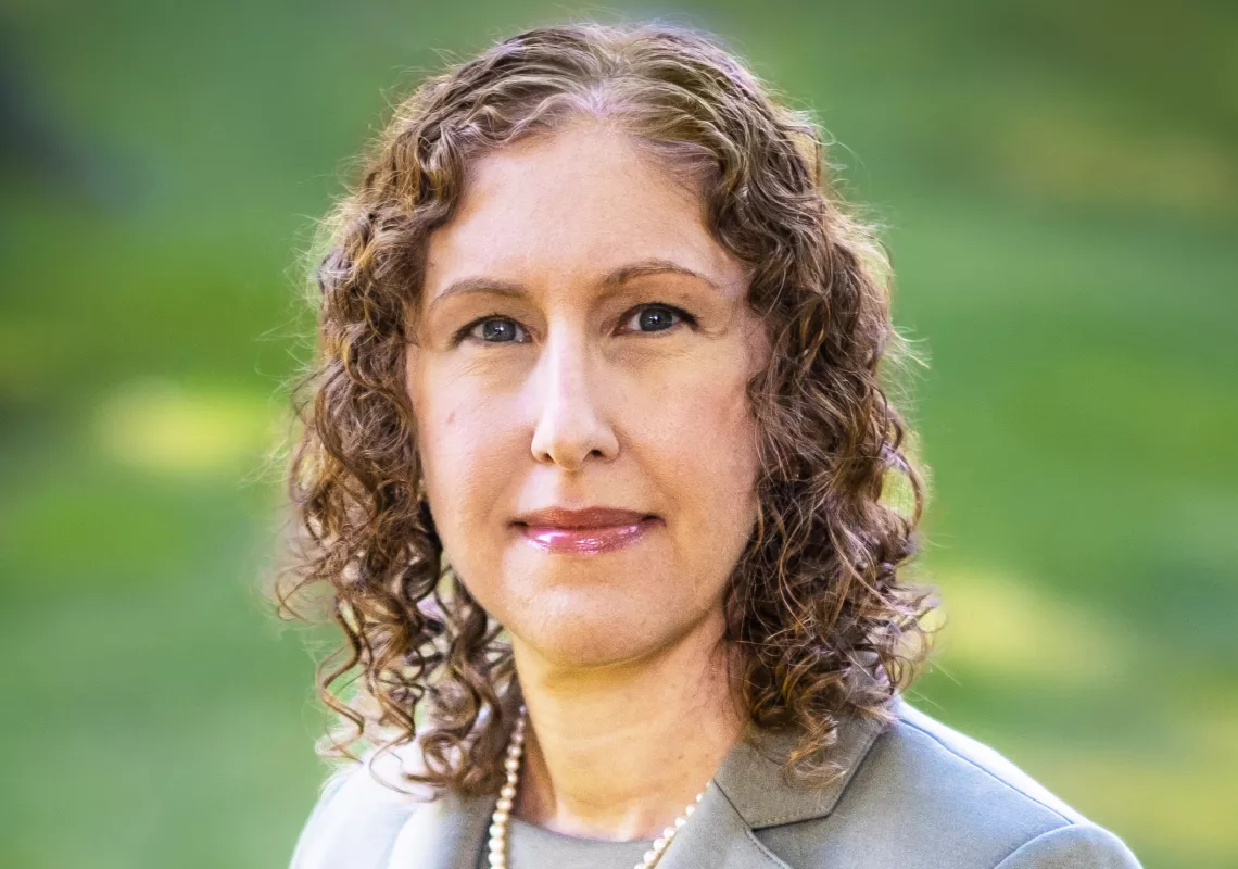 Brown haired woman in green suit