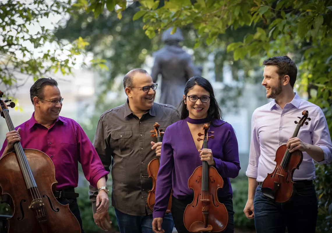 Four musicians holding string instruments