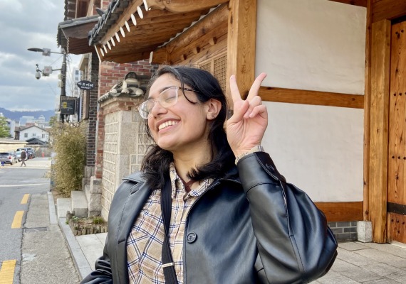 Aanandi Murlidharan posing with a peace sign outside of the Seoul Fortress