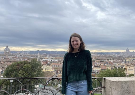 Ella Evans standing with a view of a city. 