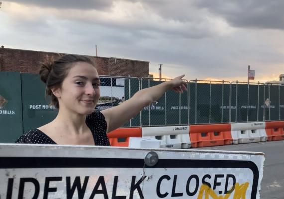 Emma Adelman in front of a sidewalk closed ahead sign. 