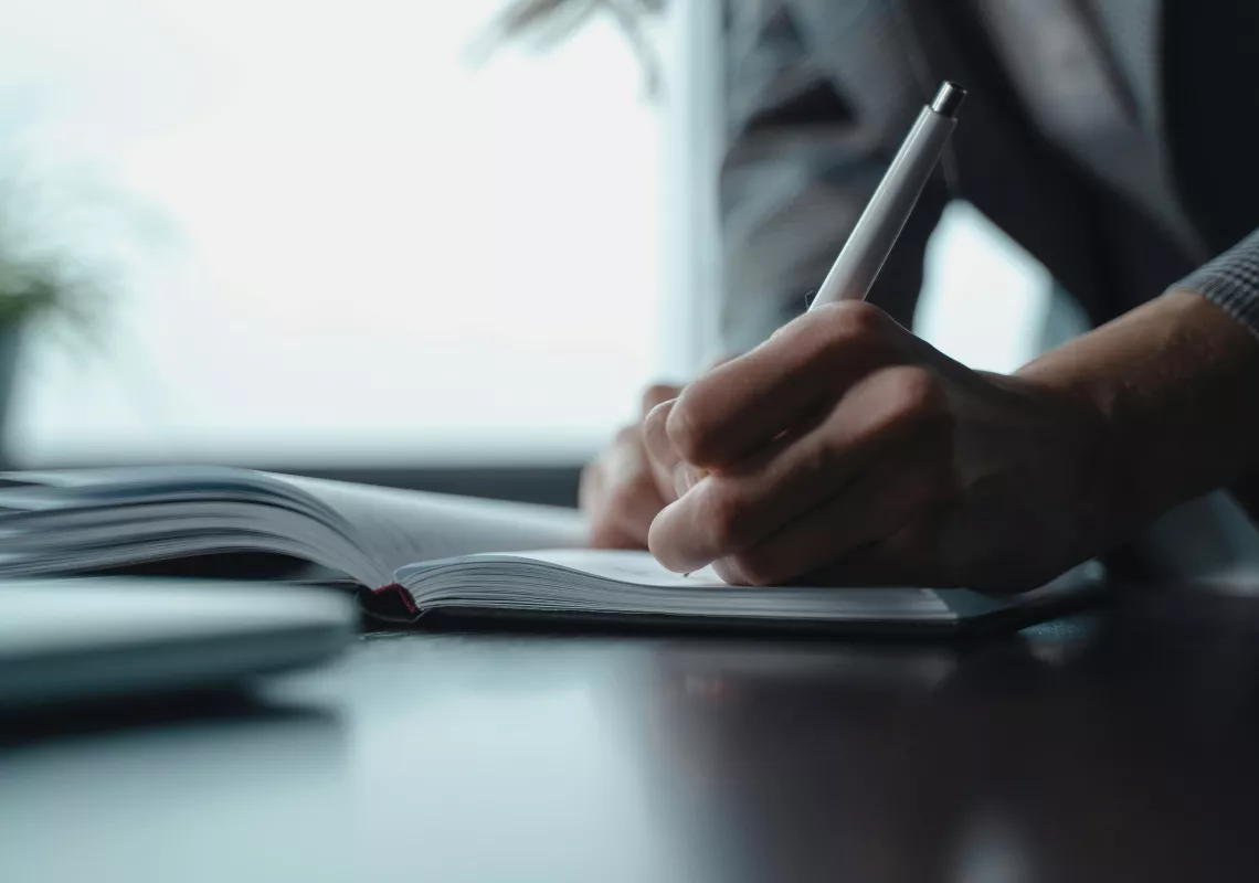 person writing in a book