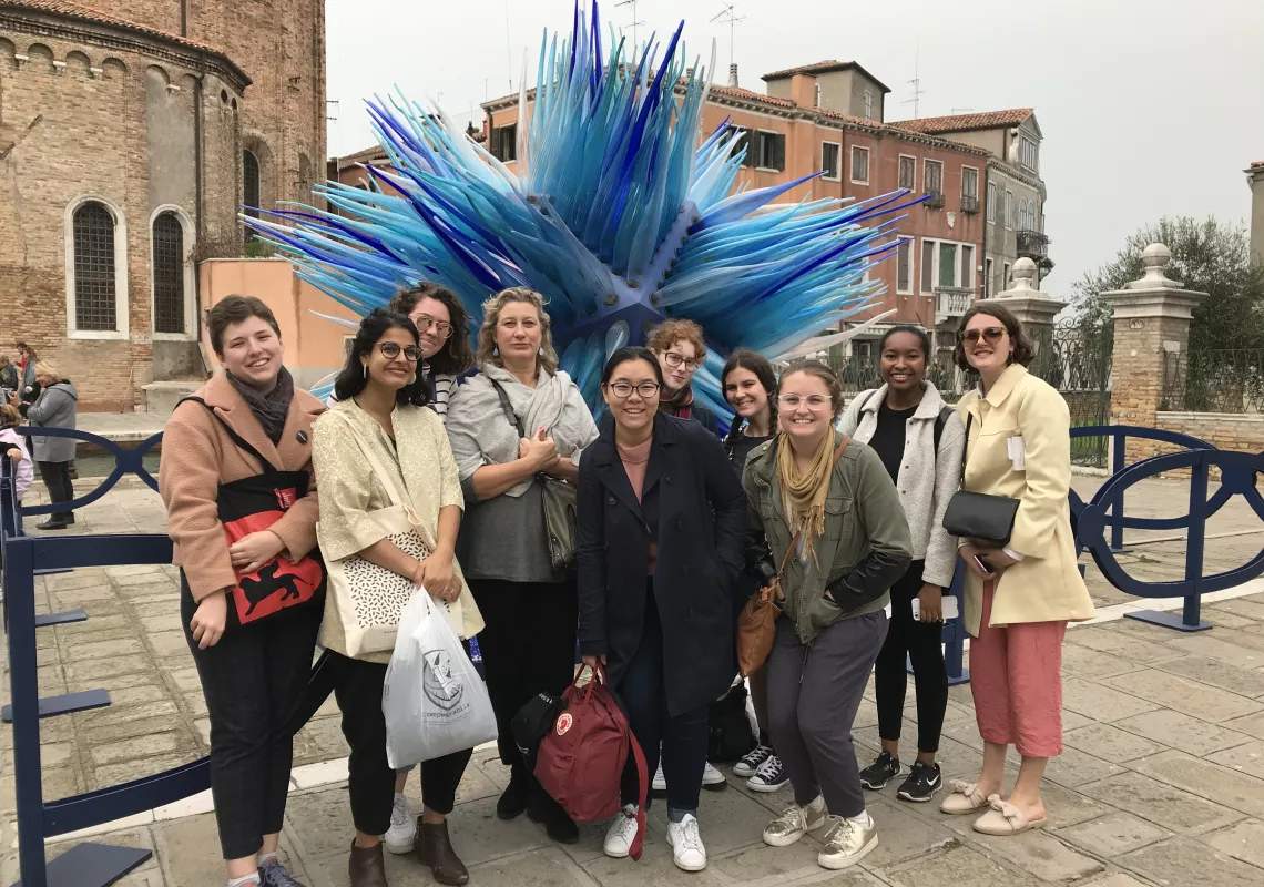 A group of students pose in front of a spiky blue sculpture at the Venice Biennale in 2018.