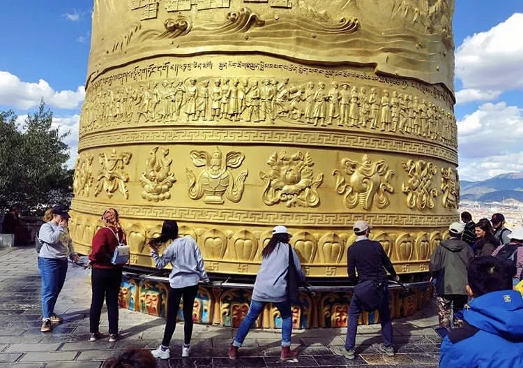 Students spinning a prayer wheel in Xishuangbanna