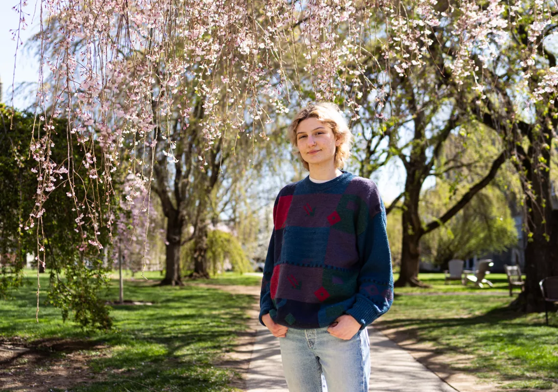 Charli Parsons '25 under the cherry blossom trees with Taylor Hall in the background