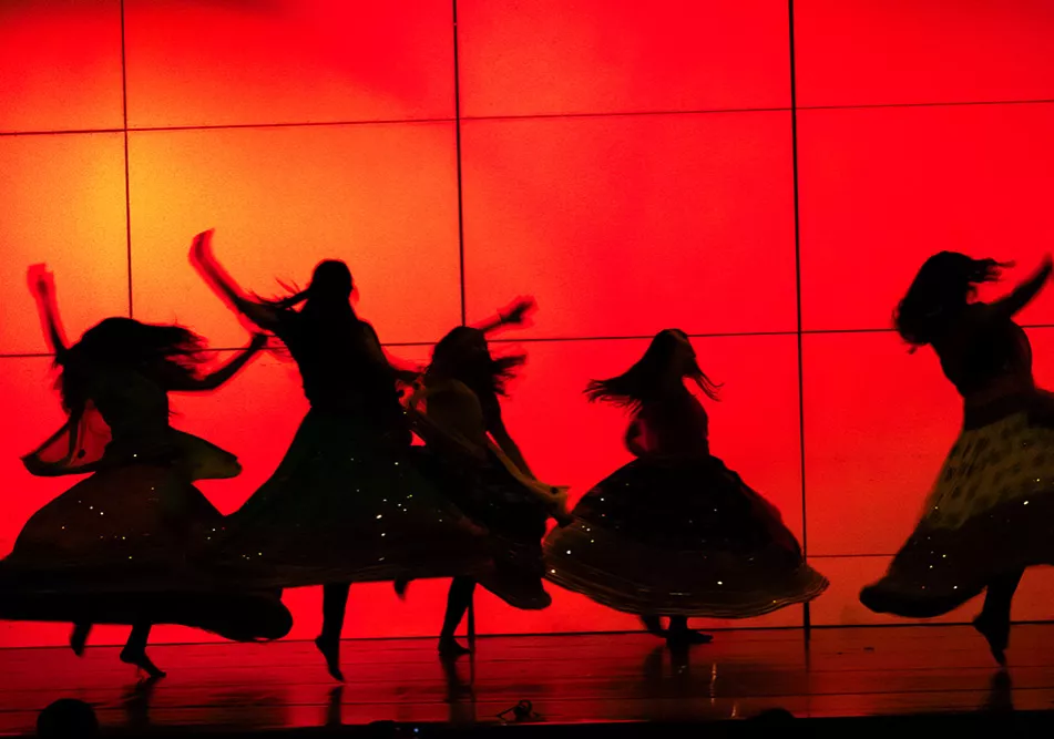 Red Background with silhouettes of student dancers