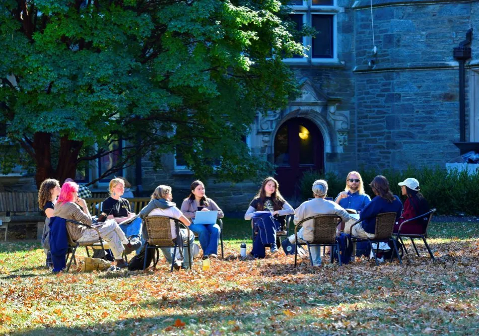 A group of adults of various ages sit in a circle.