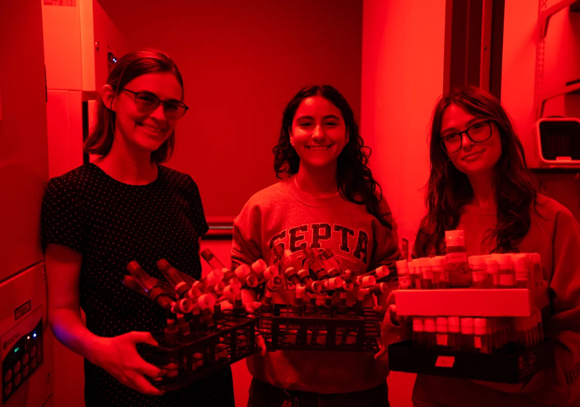 Hannah Shoenhard in her red-lit lab with students