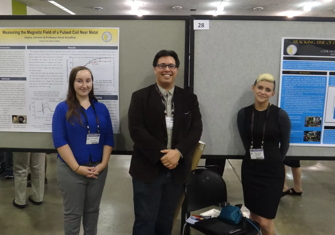 Codie Fiedler Kawaguchi and Hayley Johnson  in front of poster.