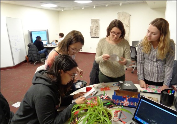 Four students with wires and a plant.