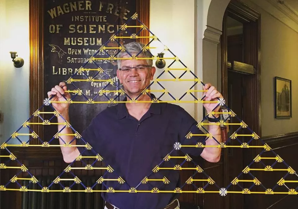 Professor of Mathematics Victor Donnay holding a triangle built of K'Nex pieces.