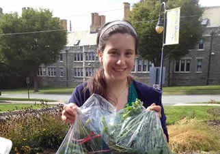 Image of student volunteer with bags of chard and kale