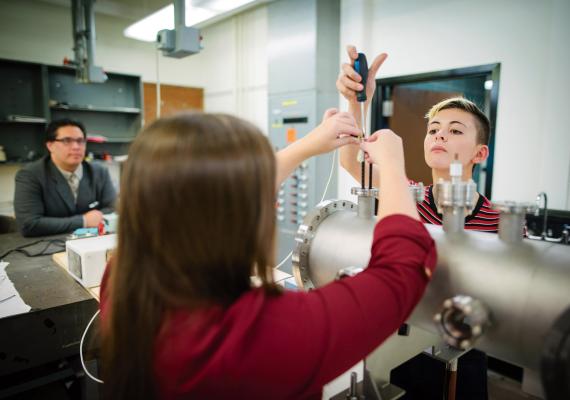 Physics professor and students working in a lab.