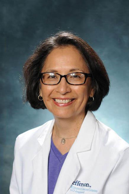 Portrait of Ana Maria López in a lab coat in front of a blue background