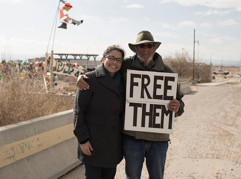 Tania Romero and Joshua Rubin holding a sign reading "Free Them"