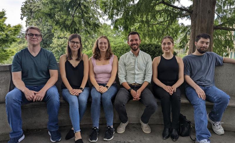 Yael, Dr. Melvin, and other students of Melvin's lab group sitting on a bench