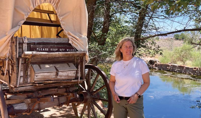 Lanita Collette next to a wagon, in front of a river