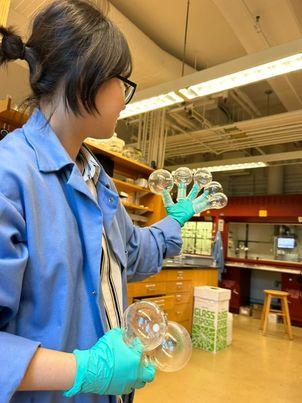 Student in lab coat working in a chemistry lab. 