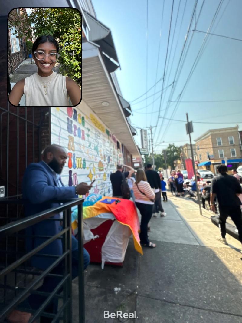 Be Real photo of Laskhmi taking a selfie in one angle, and a street view of Philadelphia in the other. 