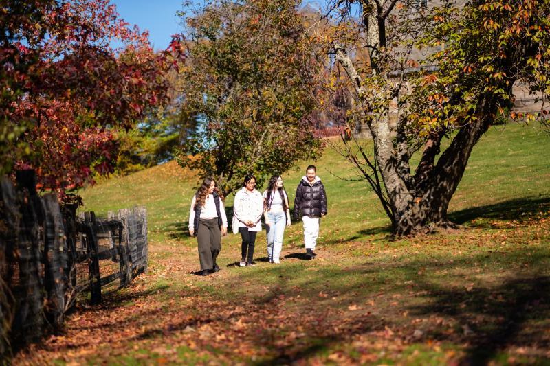 Students walking past Lake Vickers and Rhoads