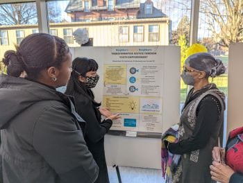 Students with community mentor at the Praxis poster session