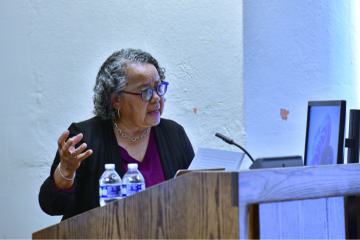 Barbara Savage speaking at a podium