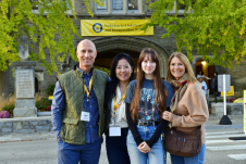 Family smiling at the camera in front of Pem Arch