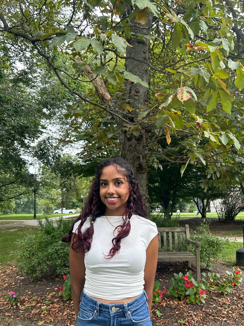 Girl wearing a white tee-shirt and smiling.