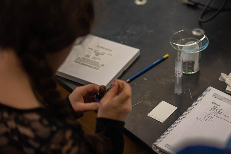 Student spotting the known and unknown dyes onto the TLC plates using glass capillary tubes.