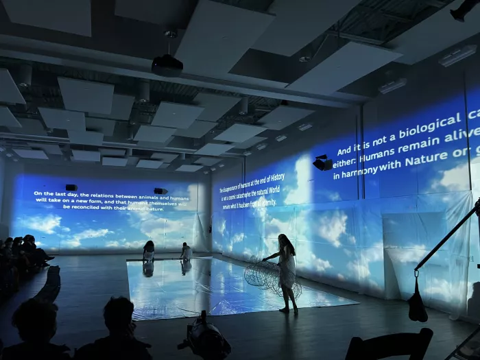 Dancer on a stage surrounded by a blue projection