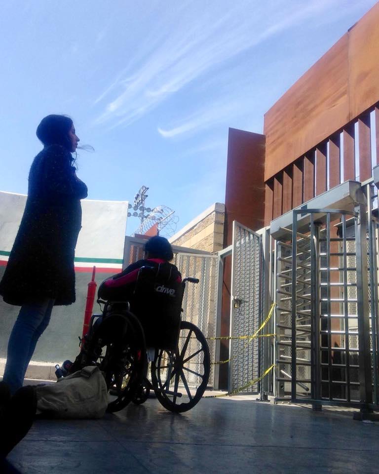 Two people outside a revolving door at the border, the door covered with caution tape