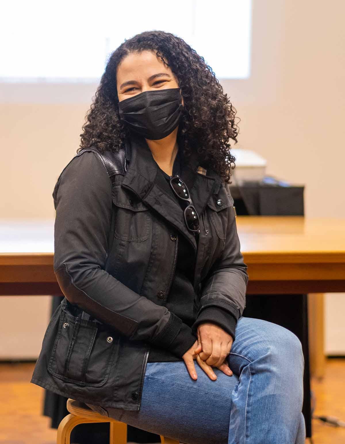 Bethany Collins sitting in a classroom in front of a slide projection