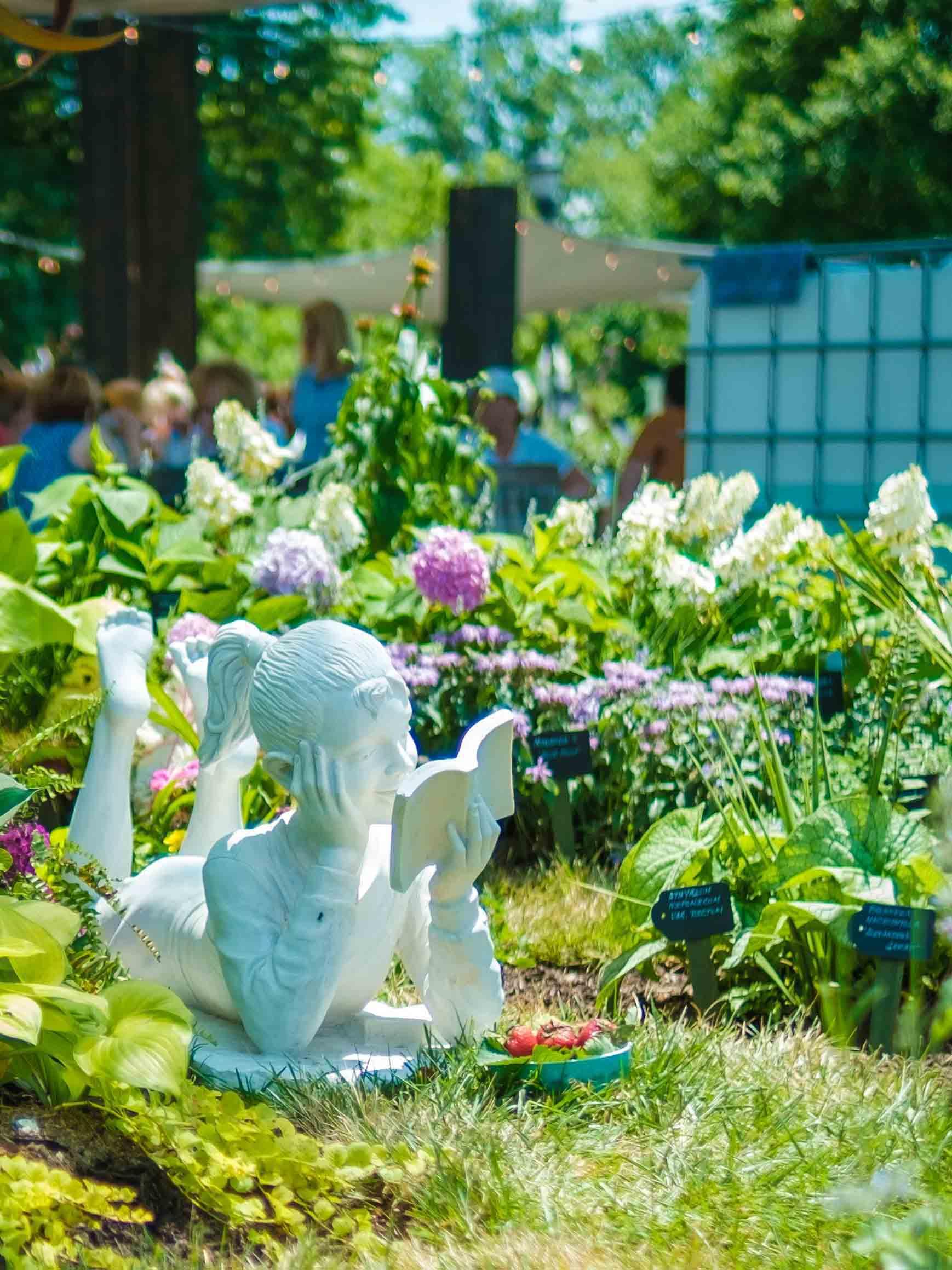 Statue of a girl surrounded by blooming flowers